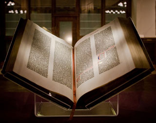 An open Gutenberg Bible displayed on a stand