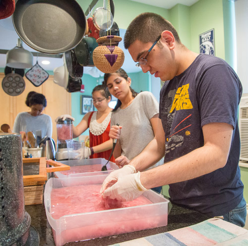 Students making paper in water-filled containers