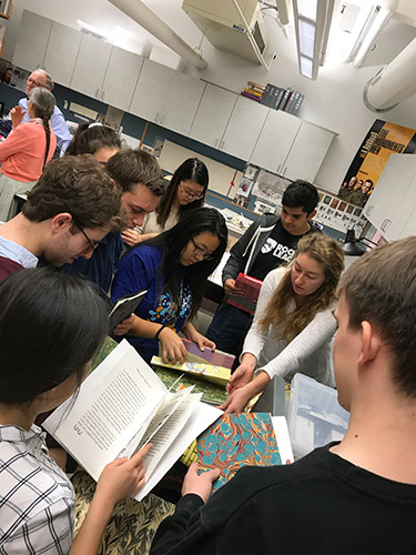 Students looking at printed copies of a booklet